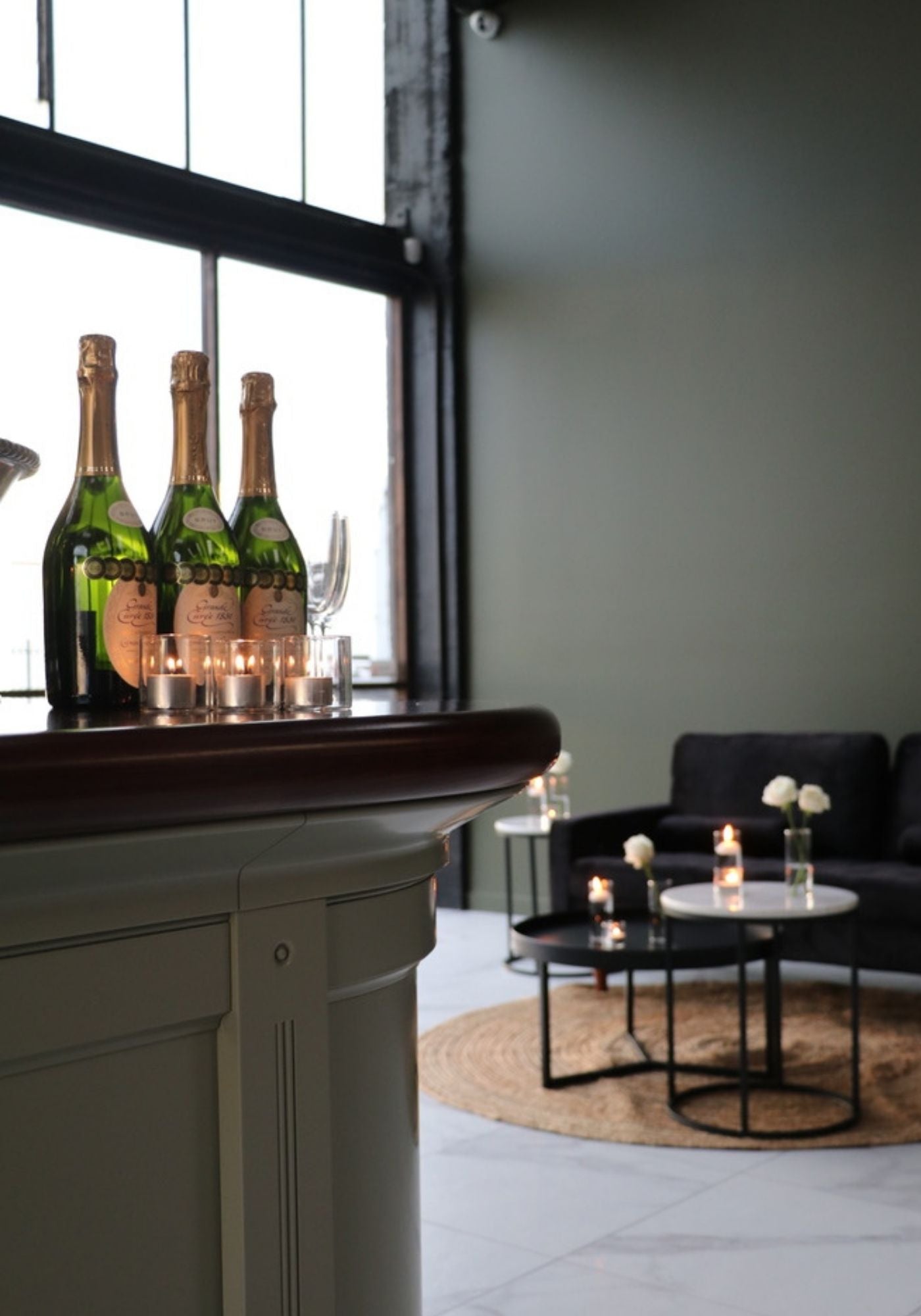 Bottles of champagne on a bar with a modern living room in the background