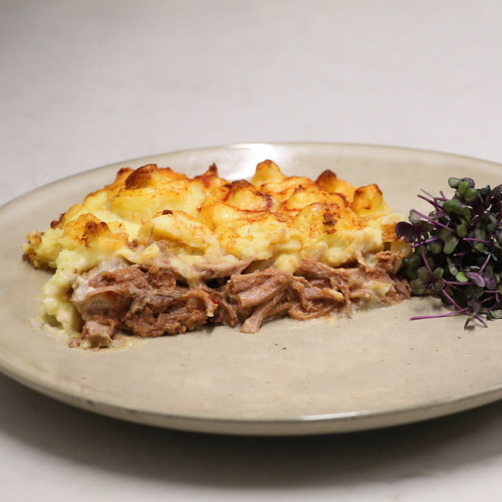 Cooked portion of the Shepards pie ready meal presented on plate with micro greens 